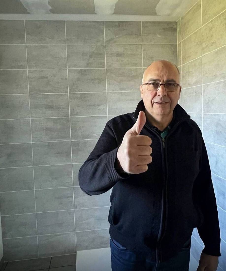 Client satisfait à la livraison du chantier : salle de bains, faïence grise
