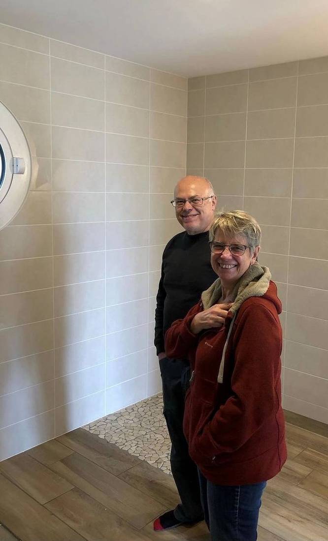 Client satisfait à la livraison du chantier : salle de bains, faïence et sol effet bois