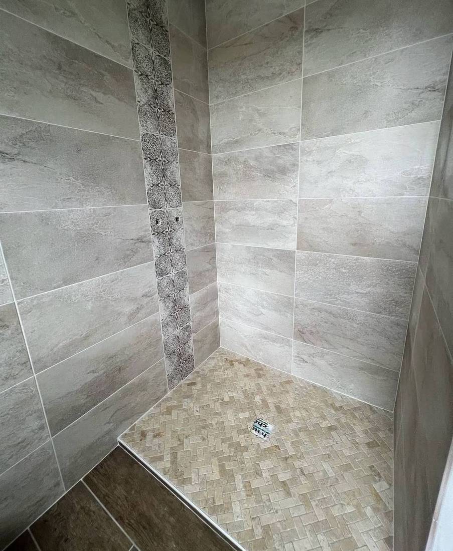 Douche avec frise décorative et sol en mosaïque à chevrons
