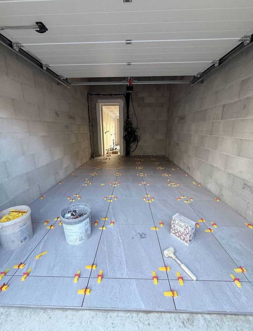 Pose de carrelage dans un garage avec système de nivellement