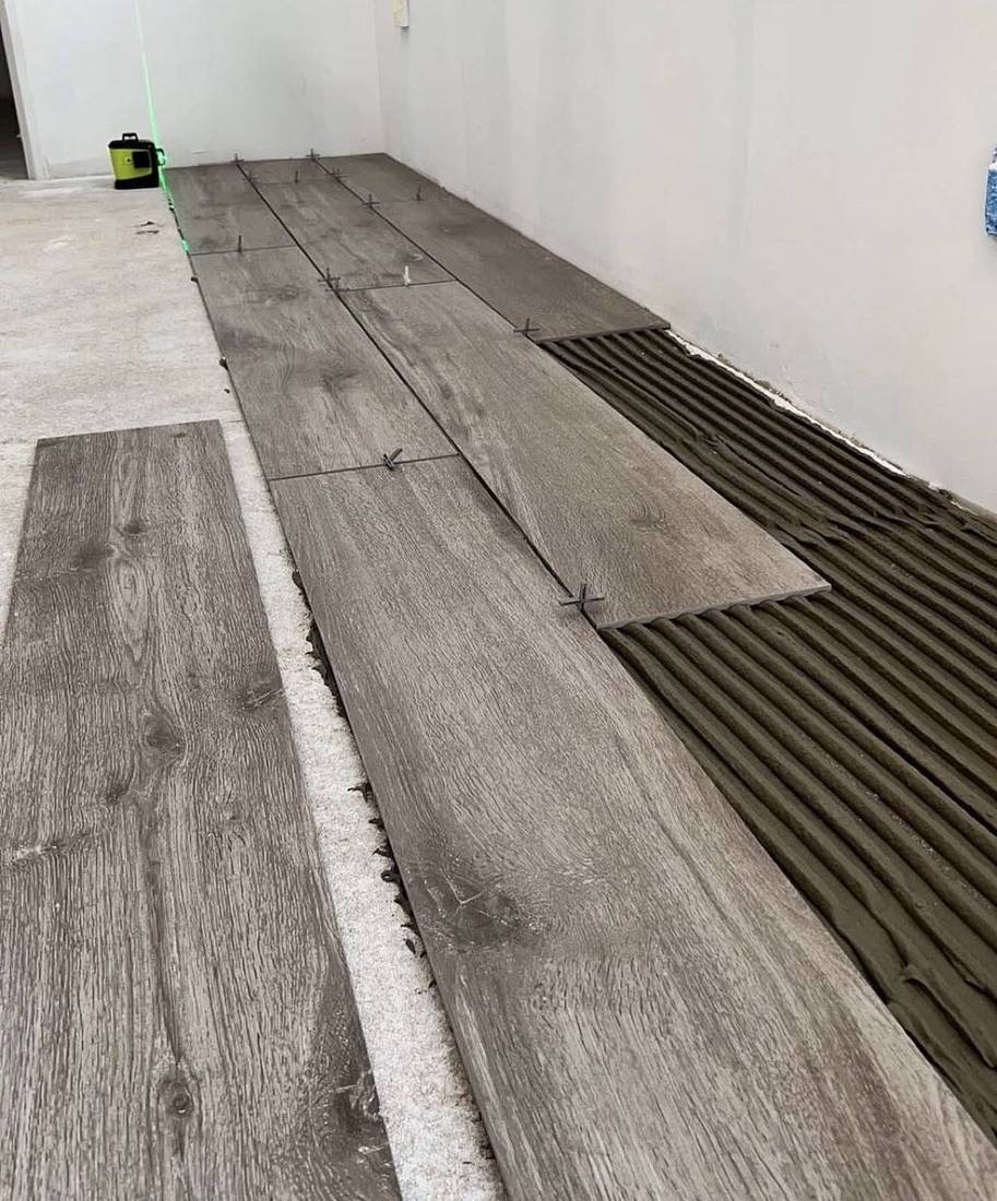 Pose collée de carrelage effet bois au laser